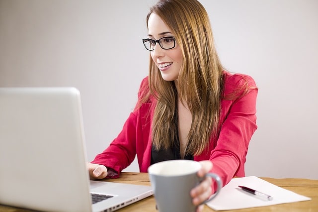 Sesión de psicoterapia online desde casa, representada por una mujer frente a su portátil.