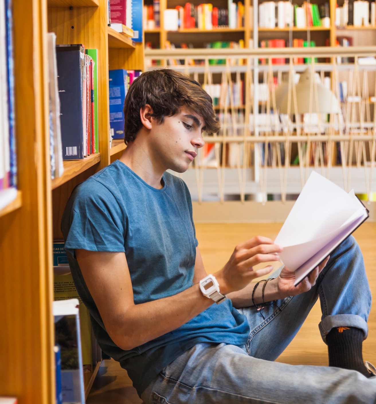 Adolescente concentrado leyendo en una biblioteca