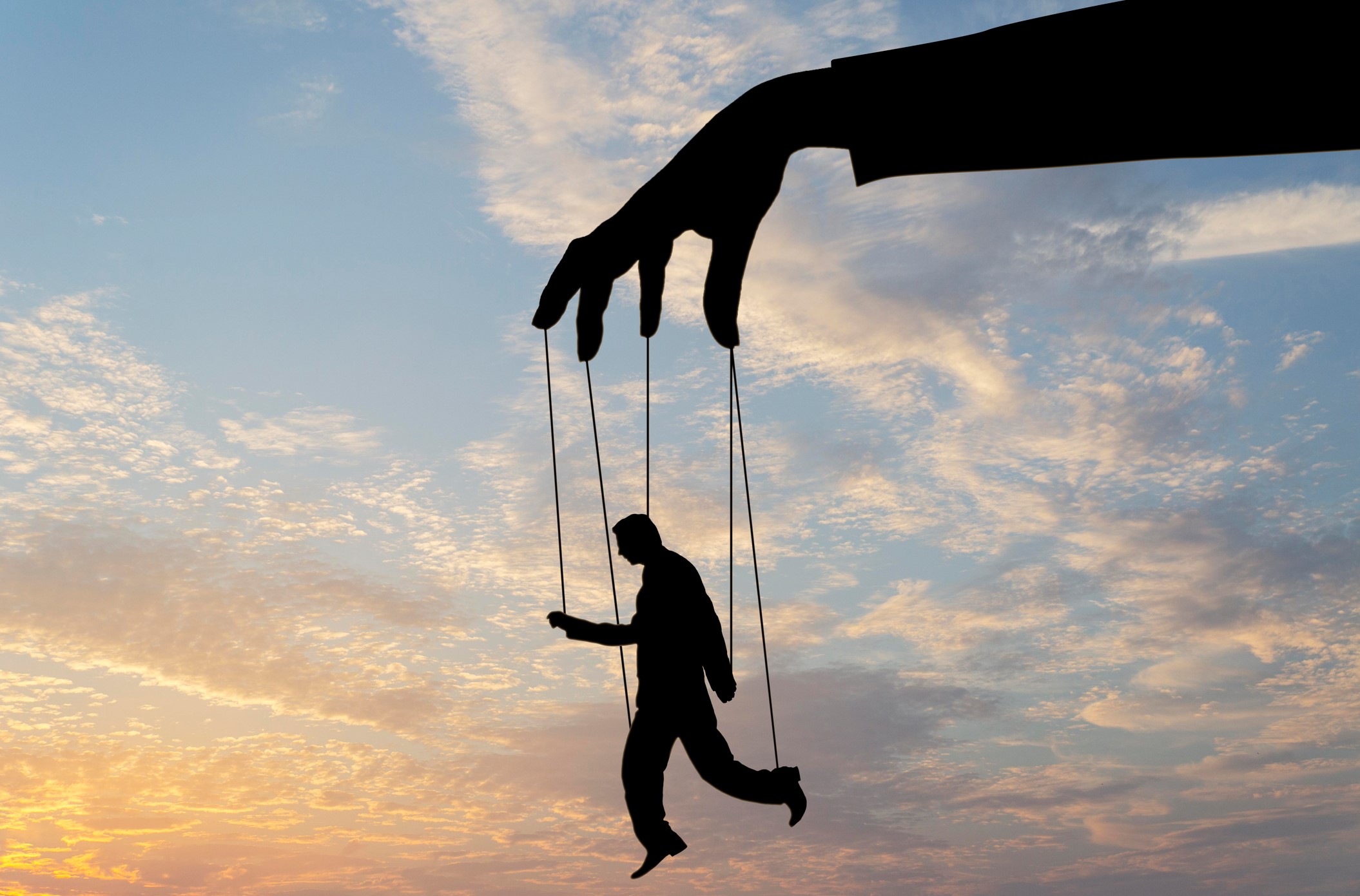 Silueta de un hombre marioneta controlado por una mano gigante, simbolizando el chantaje emocional.